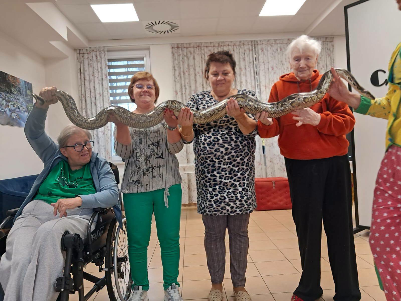 Zdjęcia- cyrk Na zdjęciu znajduje się grupa Uczestników trzymająca węża.
