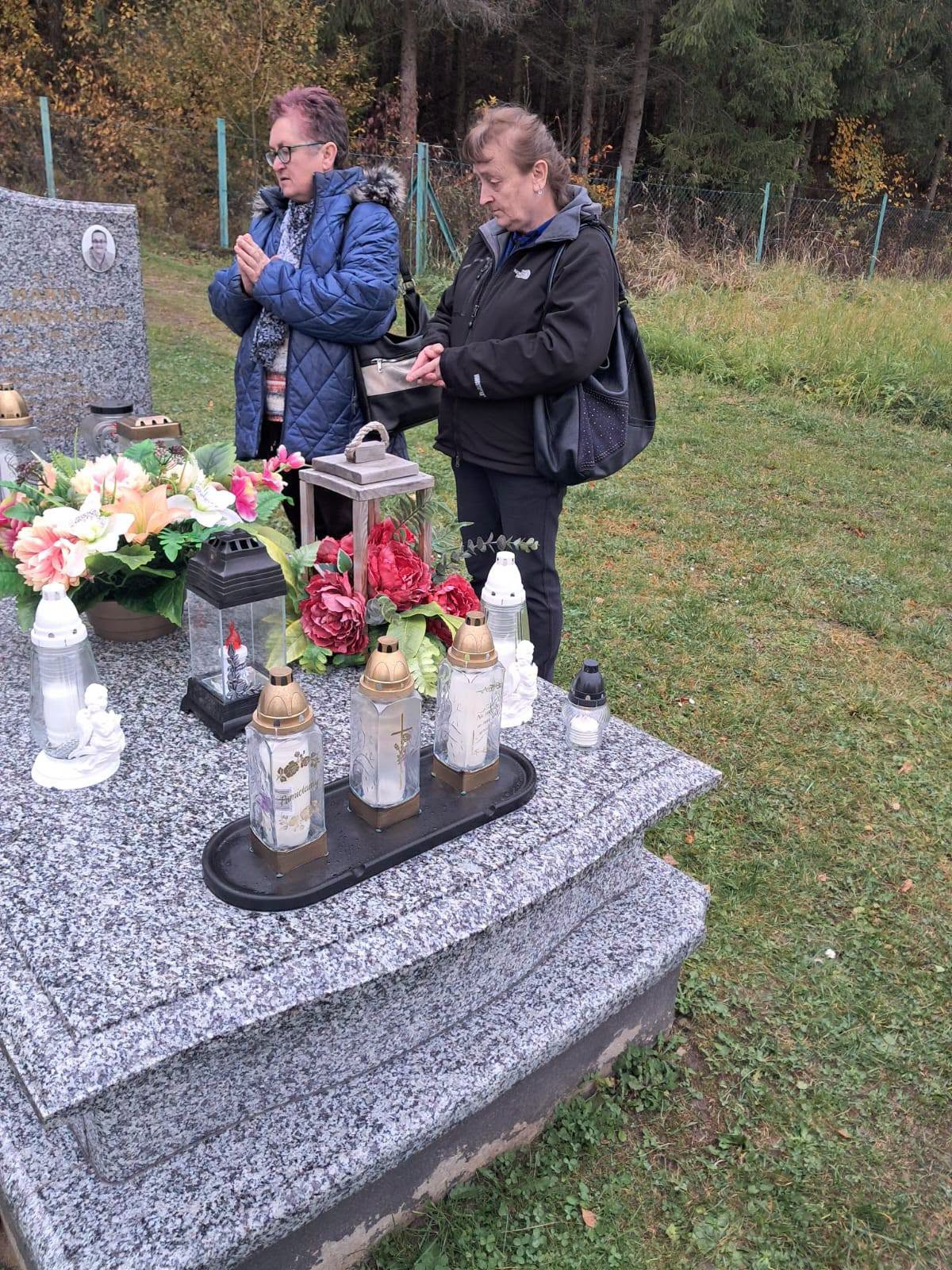 Na zdjęciu znajdują się Uczestniczki składające kwiaty na cmentarzu.
